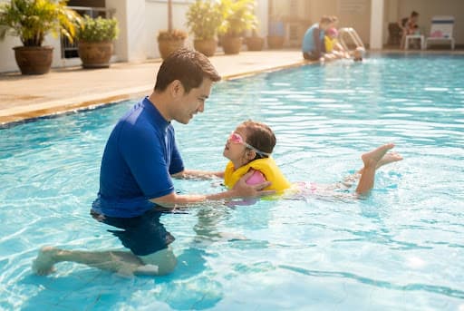 Instructor con un nino en clases de natacion