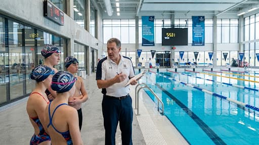 Instructor acompanando estudiantes en la piscina